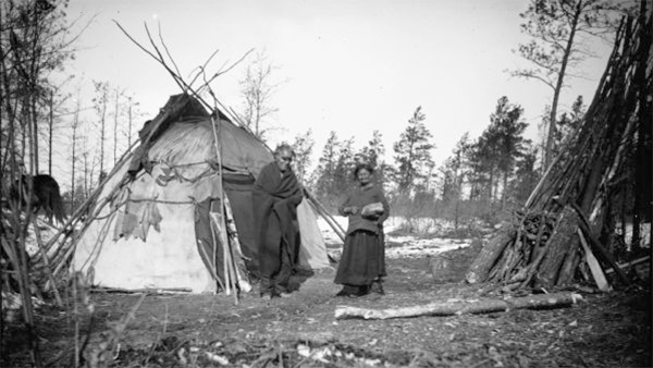 Ho-Chunk Man and Woman near Winter Lodge