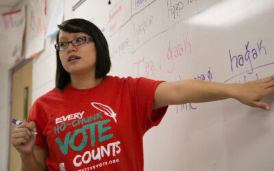 Female teacher pointing to words on whiteboard.
